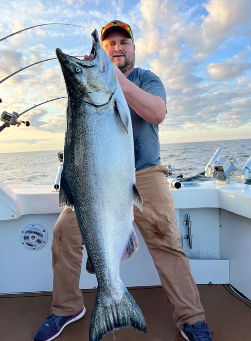 https://www.kinnskatch.com/wp-content/uploads/2023/01/Lake-Michigan-Fishing-Charters-Man-Holding-A-Salmon-hp.jpg